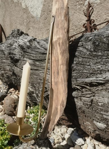 Kerzenhalter aus Messing mit Treibholz Kerzenhalter aus Messing mit einer weißen Kerze, umgeben von Treibholz